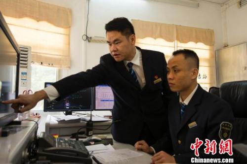 图为罗驰在指导同事工作。 覃建勋 摄