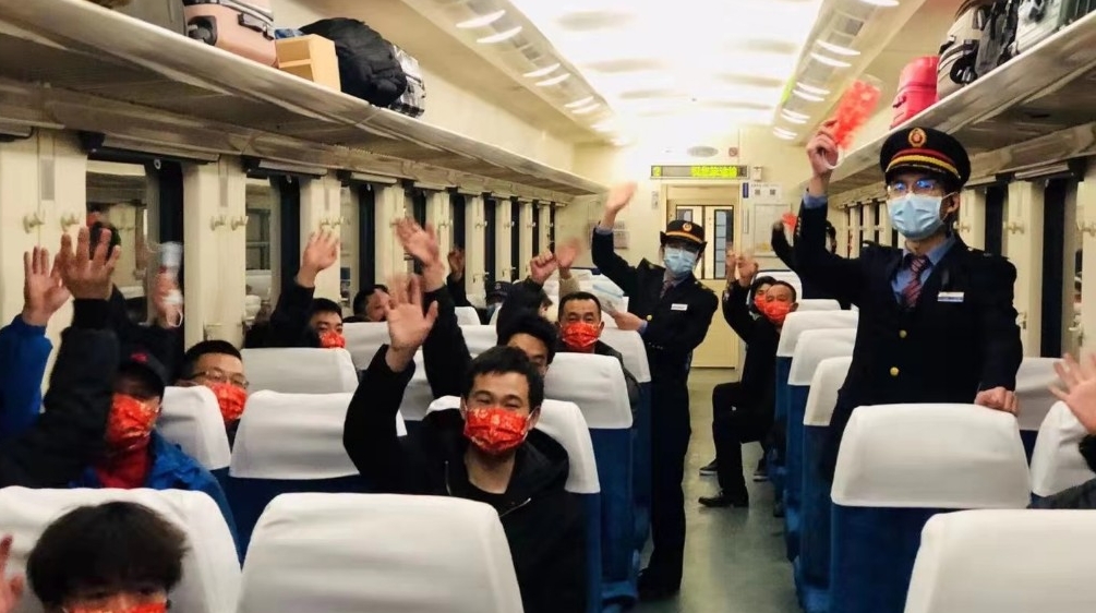 列车乘务员给乘客送“福”送口罩