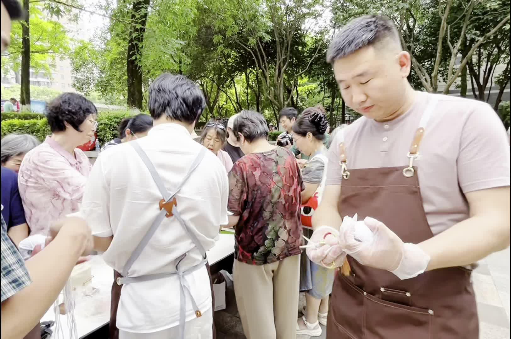社区居民跟着民宿老板学着包粽子