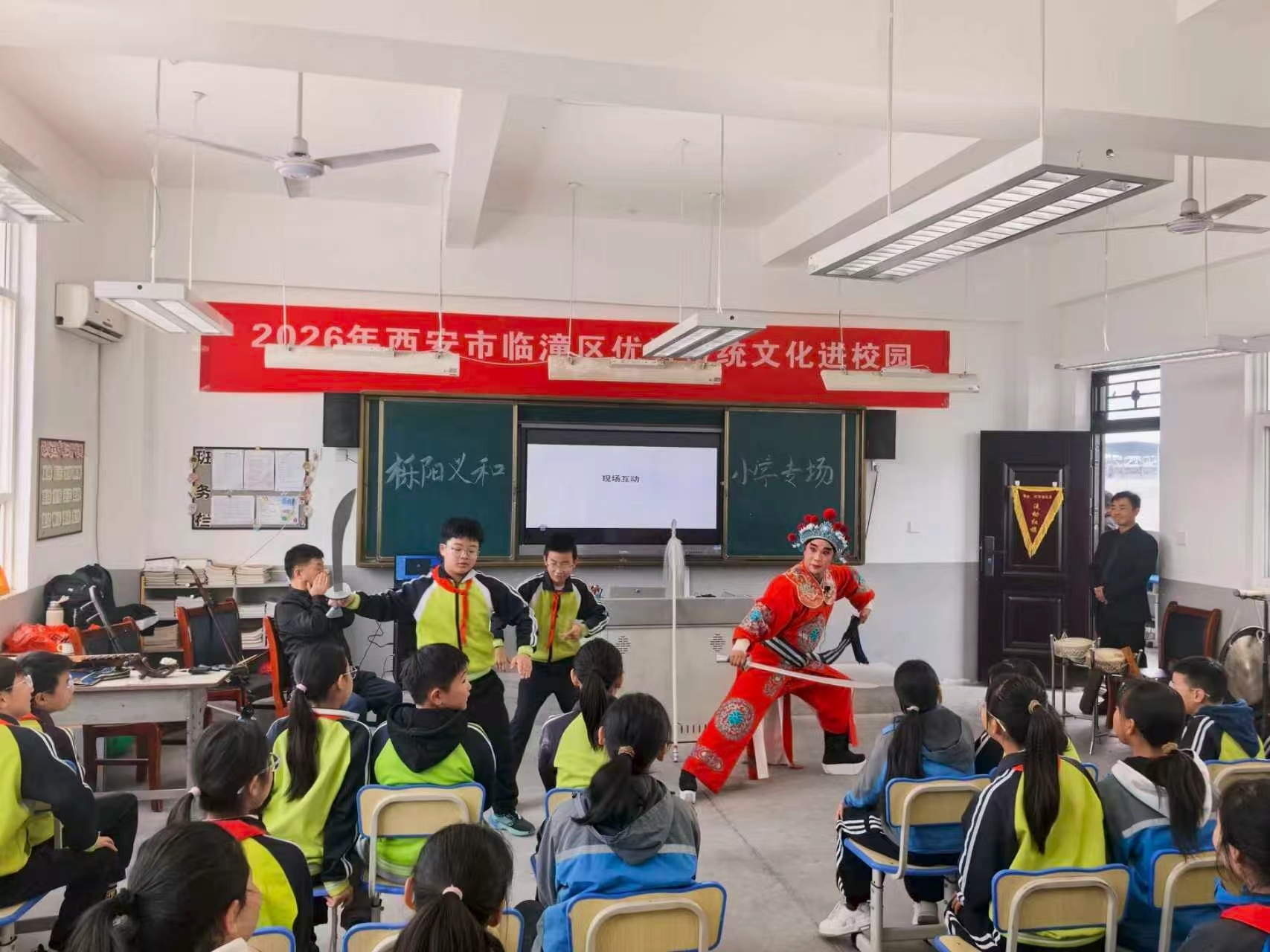 10月20日,在西安市临潼区栎阳街道义和小学,戏曲老师与学生互动表演。