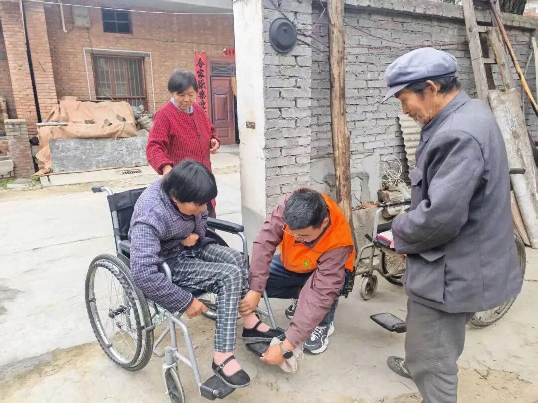 志愿者为王大爷夫妇调试轮椅 图片