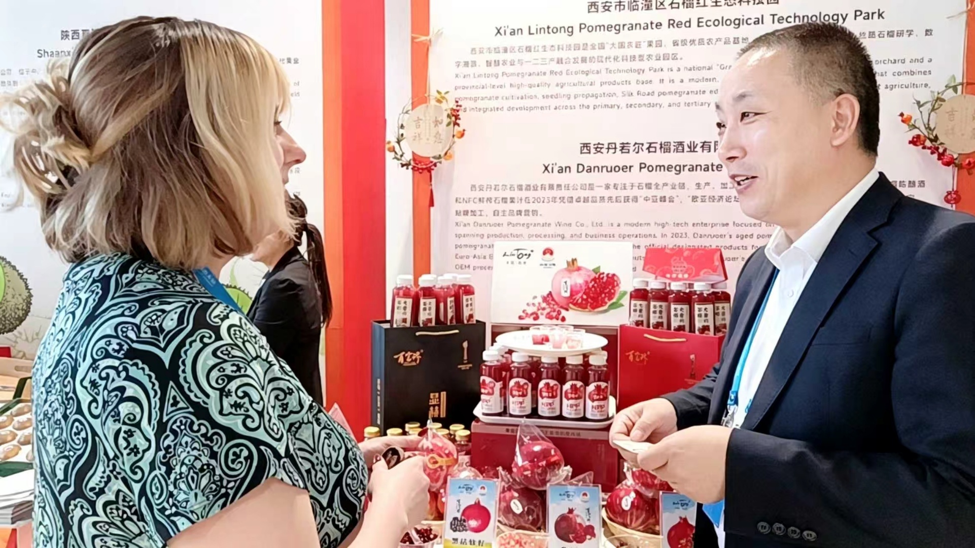 西安市临潼区石榴红生态科技园运营总监公吉贤(右一)向外国客商推介